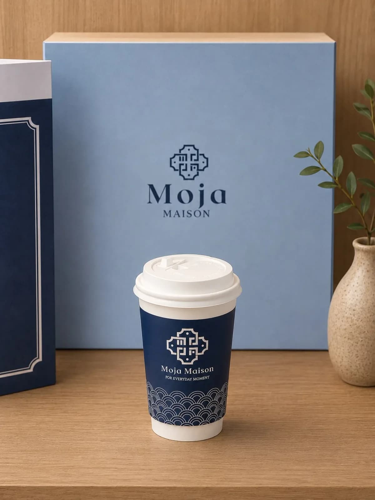 A branded Moja Maison gift box and takeaway coffee cup